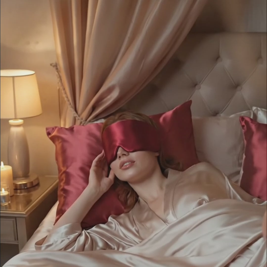 Premium Mulberry Silk Sleep Mask for Side Sleepers worn by a woman relaxing in bed with satin pillows.
